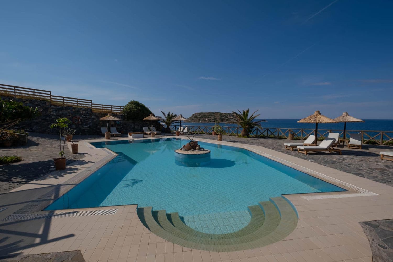 Mochlos Blue pool and sitting area, with the island of Mochlos beyond